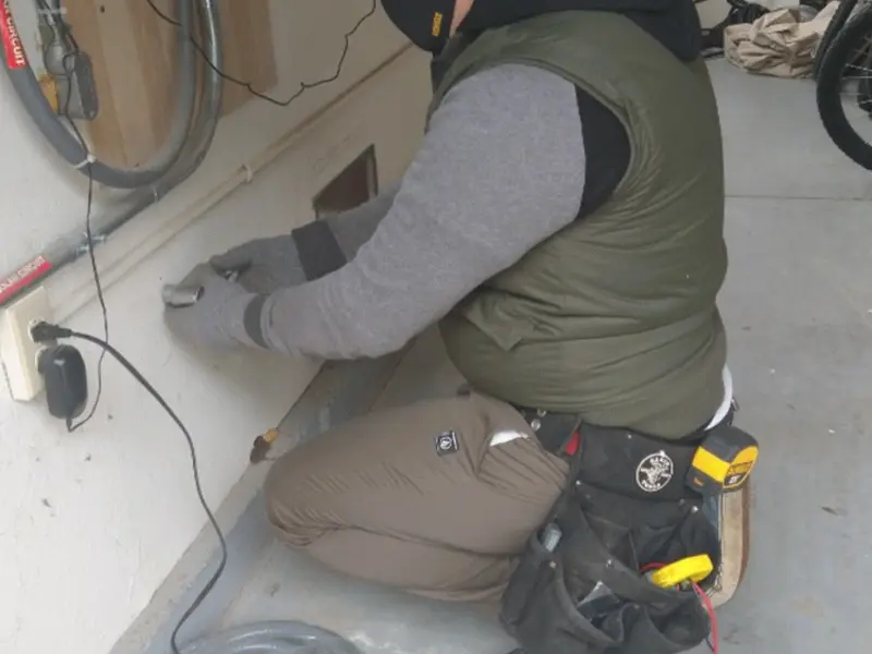 Electrician performing outlet wiring in a Woodbridge garage